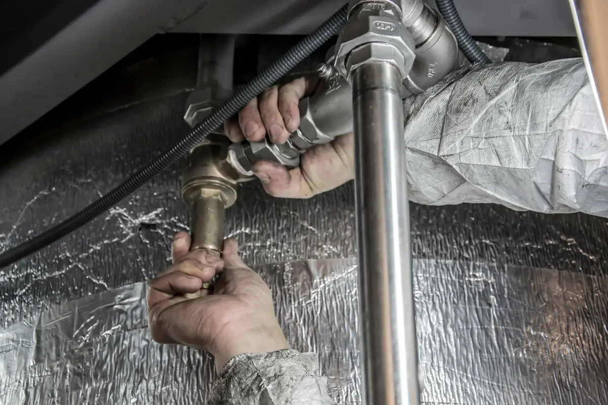 Plumber fitting steel supply pipes indoors